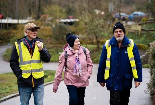 Two males and one female walking on a footpath